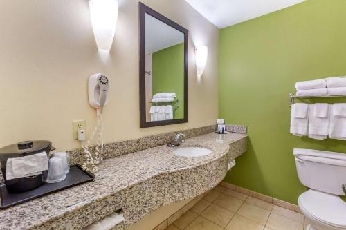 a bathroom with a toilet and a sink and a phone at Sleep Inn & Suites Jacksonville West in Jacksonville