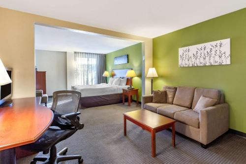 a hotel room with a couch and a bed at Sleep Inn & Suites Jacksonville West in Jacksonville