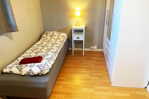 um pequeno quarto com uma cama e uma mesa de cabeceira em Newly renovated basement apartment em Sarpsborg