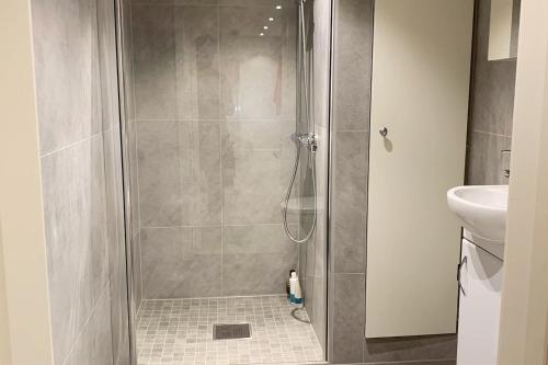 a shower with a glass door in a bathroom at Newly renovated basement apartment in Sarpsborg