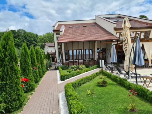 CernădiaにあるPensiunea MedAlessの建物前の傘付庭園