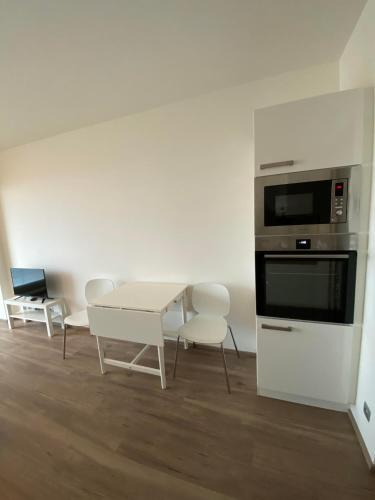 a kitchen with a table and a microwave and chairs at Apartment David O2 Arena Prague in Prague