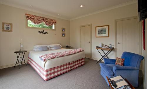 a bedroom with a bed and a blue chair at Ruapehu Country Lodge in Ohakune