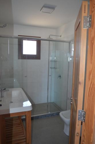 a bathroom with a shower and a sink and a toilet at Muelles del Diablo Tranquilo in Punta Del Diablo