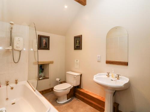 ein Badezimmer mit einem Waschbecken, einem WC und einer Badewanne in der Unterkunft The Steading in Dalmally