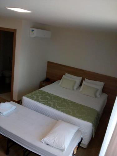 two beds in a hotel room with two bedsskirts at Suite Cond Vista Azul em Pedra Azul - Domingos Martins in Domingos Martins