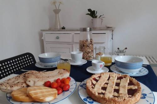 a table topped with plates of food and a pie at LE ORIGINI casa in borgo tipico lucano in Trivigno