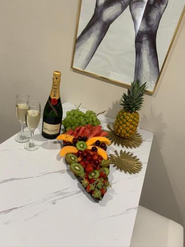 a table with a plate of fruit and a bottle of wine at Hotel Elite in Varcaturo