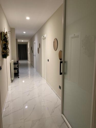 a hallway with white tile floors and a glass door at Hotel Elite in Varcaturo