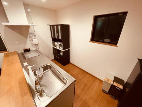 a kitchen with a sink and a television on the wall at L's Mt.Fuji vacation rental in Fujikawaguchiko
