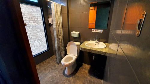 a bathroom with a toilet and a sink at Phooree Boutique Hotel in Nakhon Si Thammarat