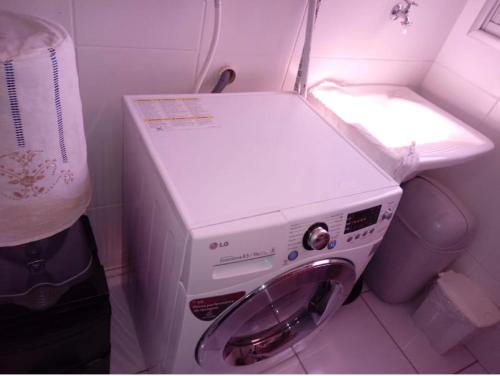 a washing machine in a bathroom with a sink at Aconchegante apto em localização privilegiada in Cuiabá