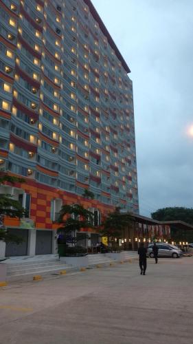 a large building with people walking in front of it at Apartemen Riverview Residence Jababeka at KiNGDOM Rent Apartment Solution in Cikarang