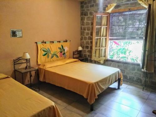 a bedroom with two beds and a window at Posada Ribera del Gualeguaychu in Gualeguaychú
