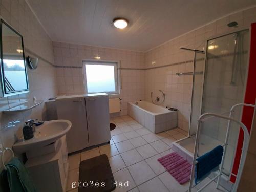 W łazience znajduje się wanna, prysznic i umywalka. w obiekcie Kastner Monteurwohnung w mieście Neubörger