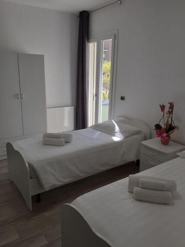 two beds in a white room with a window at Giosam Bed & Breakfast di Raimondo Isabelle in Pozzilli