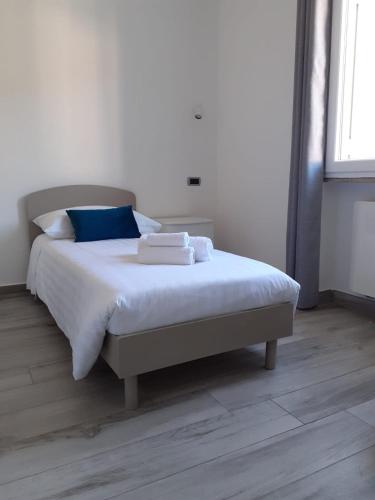 a bedroom with a bed with white sheets and blue pillows at Giosam Bed & Breakfast di Raimondo Isabelle in Pozzilli