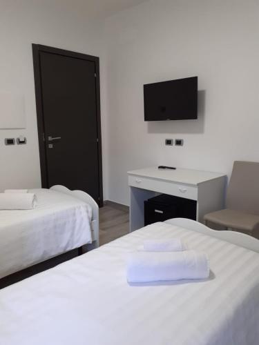 a room with two beds and a desk and a tv at Giosam Bed & Breakfast di Raimondo Isabelle in Pozzilli