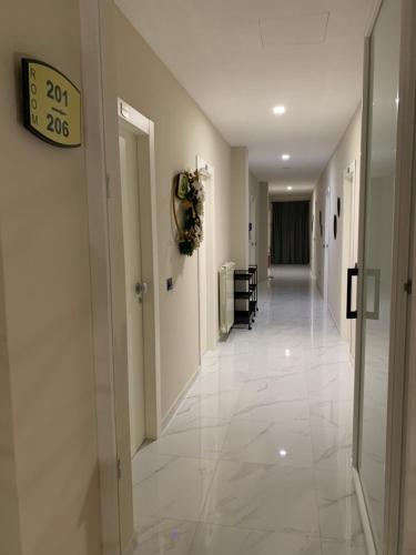 a hallway with white tile floors and a clock on the wall at Hotel Elite in Varcaturo