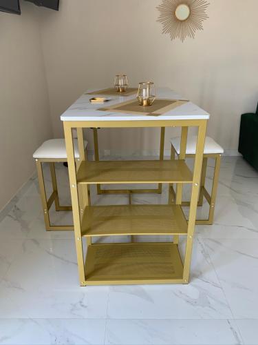 a small yellow table with two shelves in a room at Hotel Elite in Varcaturo
