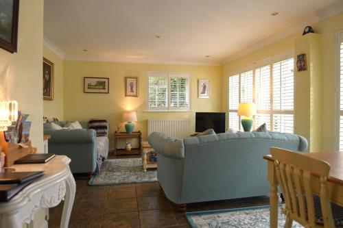 a living room with a couch and a tv at Rushcroft Farm Cottages in Sway