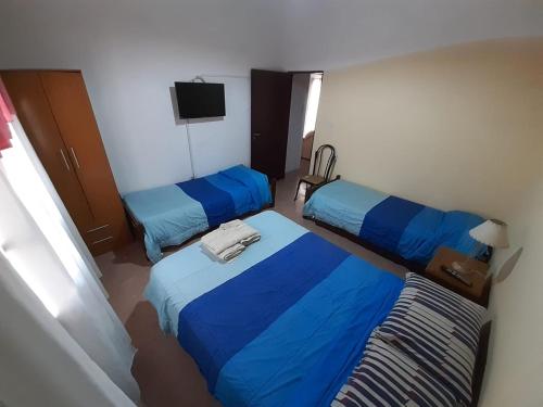 um quarto de hotel com duas camas e uma televisão em Hotel Mitre Chivilcoy. Casa en Rivadavia 900 em Chivilcoy