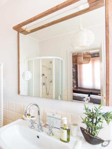 a bathroom sink with a large mirror above it at Le Camere Pietrasantine - Centro Storico in Pietrasanta