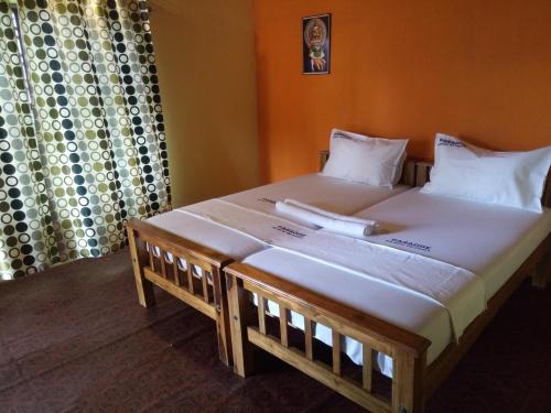 a bedroom with a large bed with white sheets at SEVENSTAR RESIDENCY in Varkala