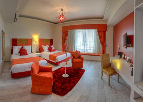 Habitación de hotel con 2 camas y 2 sillas en Hotel Andante, en Puebla