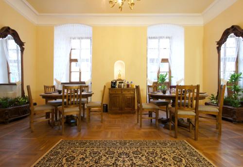 a dining room with tables and chairs and windows at Palace Kutná Hora in Kutná Hora