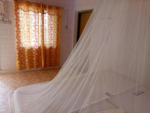 1 cama con mosquitera en una habitación con ventana en SEVENSTAR RESIDENCY en Varkala