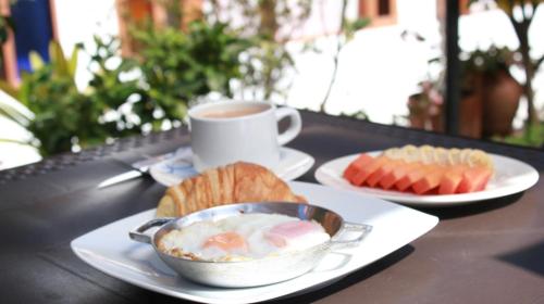 a table with two plates of food and a cup of coffee at Villa Pepita Real in Villa de Leyva