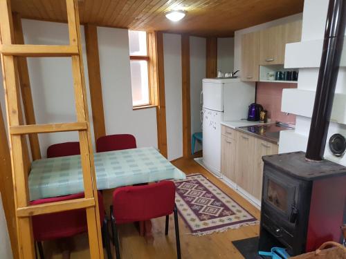 una cucina con fornelli, un tavolo e una scala di Captain s house a Konjic