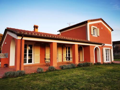 a red and white house with a yard at B&B Luna Nuova in Sarzana