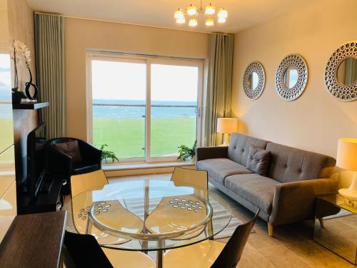 a living room with a couch and a glass table at Stunning Sea Views, luxury apartment beaches & restaurants are a short walk away in Newquay