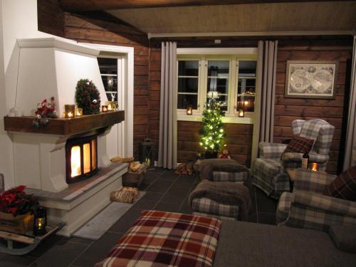 a living room with a christmas tree and a fireplace at Malangen Lodge in Mestervik