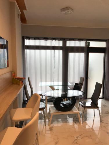 a dining room with a glass table and chairs at Guest House Bracciano RM in Bracciano