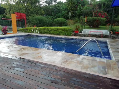a pool with a hose in a yard at The House of Hummingbird in Atenas