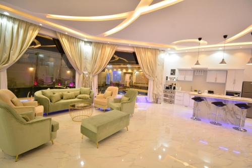 a large living room with couches and a kitchen at شالية ديور الفندقي in Al Wudayy