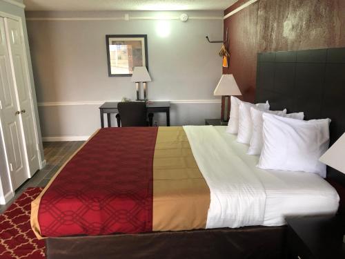 a hotel room with a large bed with a colorful blanket at KINGS INN- Medical Downtown Midtown Memphis in Memphis