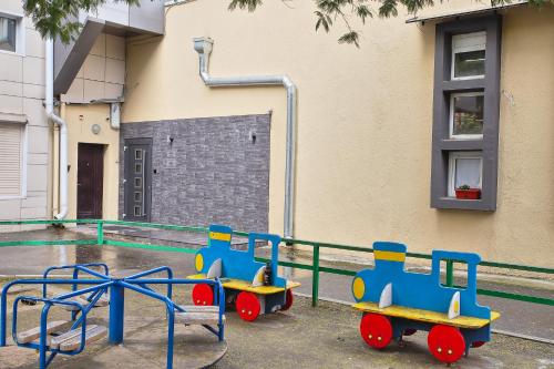 a toy train on a playground in front of a building at Отель Максим Горький in Sochi