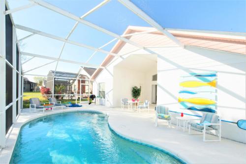 a swimming pool in a house with a glass ceiling at Making Dreams 4BR Family Villa with Pool and Game Room Near Disney Parks in Kissimmee