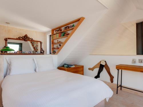 a bedroom with a white bed and a staircase at The Artists House by The Sea in Herne Bay