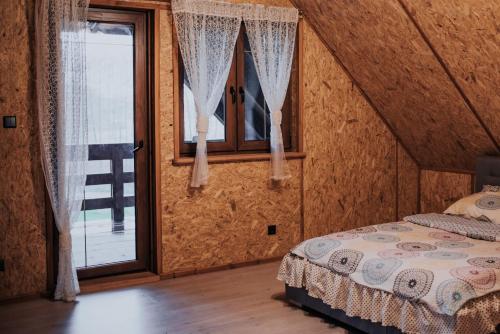 um quarto com uma cama e uma janela em Cichy drewniak em Miłomłyn
