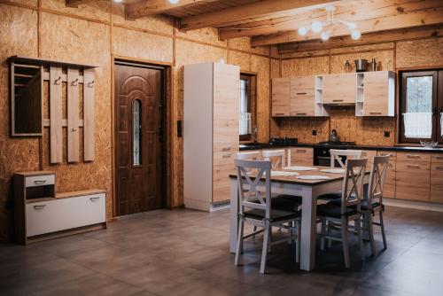 a kitchen with a table and chairs in it at Cichy drewniak in Miłomłyn