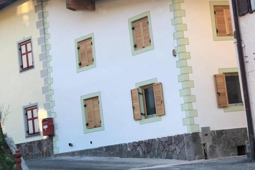 a building with windows on the side of it at La casa! in Vigo di Fassa