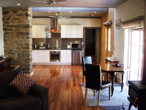 a living room with a table and a kitchen at 1860 Wine Country Cottages in Springton