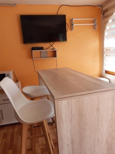 Habitación con mesa, 2 sillas y TV. en Isla de Lagos I en Ushuaia