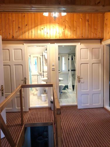 a room with a bathroom with two doors and a staircase at Ibis in Sovata