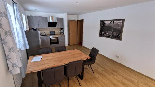 a kitchen with a wooden table and chairs in a room at Ferienhaus Wetterstein in Grainau